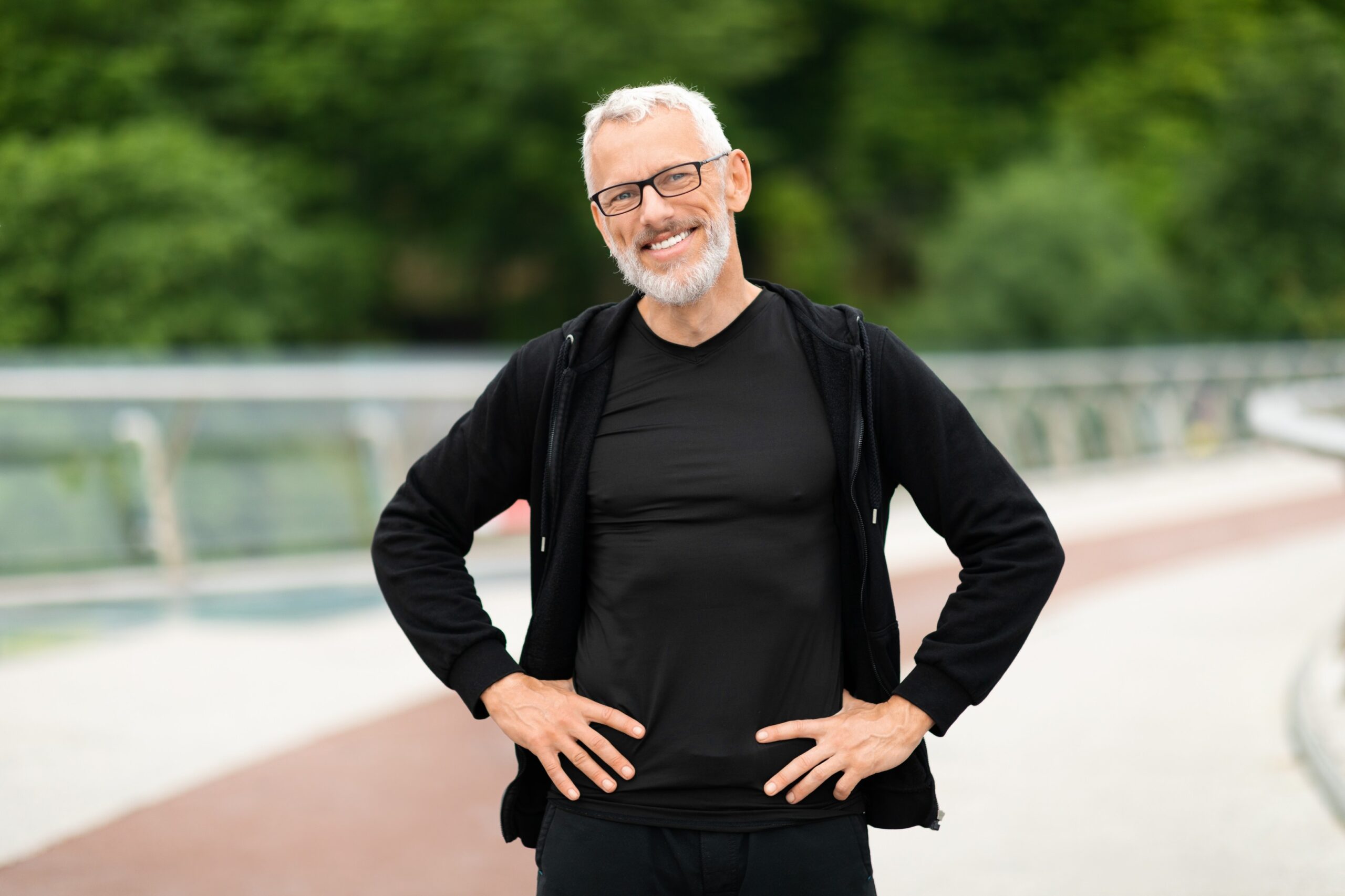 happy-well-fit-senior-sportsman-jogging-by-street-GQEZ2P5